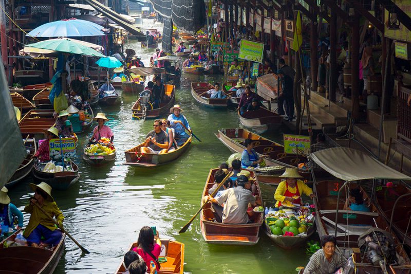 RATCHABURI, THAILAND - MARCH 24: Local peoples sell fruits, food and souvenirs at famous tourist attraction Damnoen Saduak floating market on March 24, 2014 in Ratchaburi, Thailand.